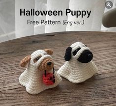 two crocheted dogs sitting next to each other on a wooden table with the text halloween puppy free pattern