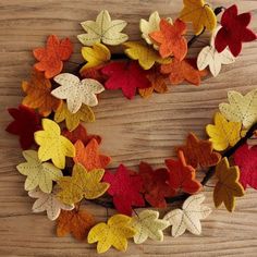 a wreath made out of felt leaves on a wooden table