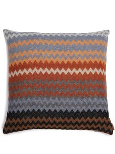 an orange, grey and black pillow on a white background