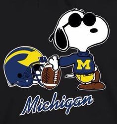 a black shirt with a cartoon dog holding a football helmet and the word michigan on it