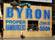 a large sign on the side of a building that says byron proper hamburgers soon