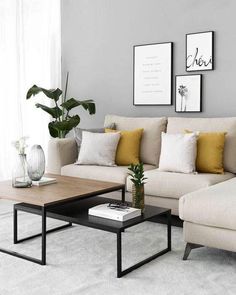 a living room with couches, coffee table and pictures on the wall above them