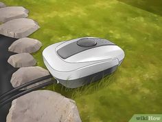 a white boat sitting on top of a lush green field next to rocks and water