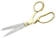 a pair of gold colored scissors on a white background with clippings for the handles