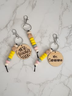 two wooden key chains with personalized charms