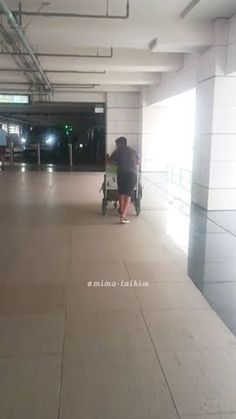 a person pushing a stroller in an empty parking garage with no one on it