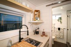 a kitchen area with sink, counter and window