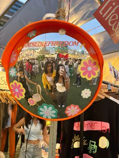 a mirror that is hanging on a pole in front of some clothes and other items