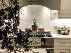 a kitchen with white cabinets and an oven in the center is decorated with christmas decorations