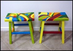 two brightly colored stools sitting next to each other on the floor in front of a wall