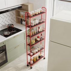 a red rack filled with lots of food next to a stove top oven in a kitchen