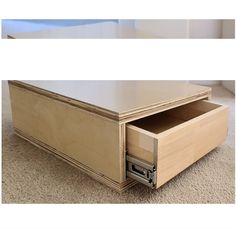 an open drawer on the bottom of a coffee table that is sitting on carpeted floor