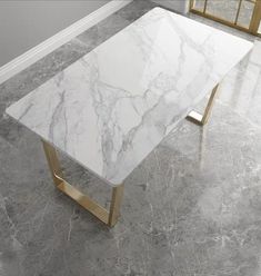 a white marble table with gold legs in a room