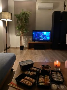 a living room filled with lots of food and a tv on top of a wooden table