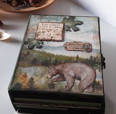 an altered box with a bear on it and other items around the box in the background