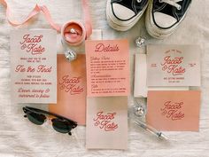 the wedding stationery is laid out with sunglasses, napkins, and other items