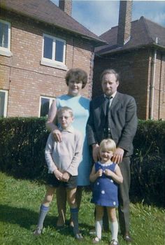 a family poses for a photo in front of their house