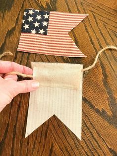 someone is making an american flag banner out of burlap and twine on the table