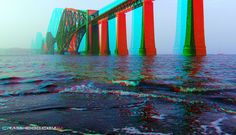 an image of a bridge going over the water with red, green and blue colors