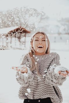 a woman is throwing snow in the air