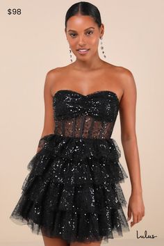 The Lulus Illustrious Glow Black Sheer Tulle Sequin Tiered Mini Dress is perfect for any occasion that calls for extra extravagance! This sensational dress features a sparkling sequin design across the tulle-mesh construction that shapes a strapless, bustier-inspired bodice with sheer mesh paneling (along with supportive boning), a gathered bust with padded cups, and a sweetheart neckline with hidden no-slip strips. The high, fitted waist sits atop a fun and frilly tiered skirt that finishes at Black Dress Glitter, Fall Cocktail Dress, Black Wedding Guest Dresses, Casual Formal Dresses, Strapless Bustier, Tiered Mini Dress, Sequin Design, Casual Wedding Dress, Black Short Dress