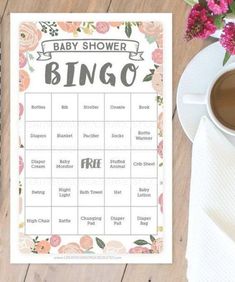 a baby shower game with pink flowers on the table and a cup of coffee next to it