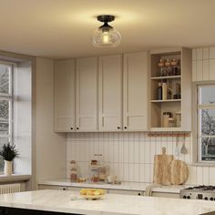 a kitchen with white cabinets and an island in front of a window that is open to the outside