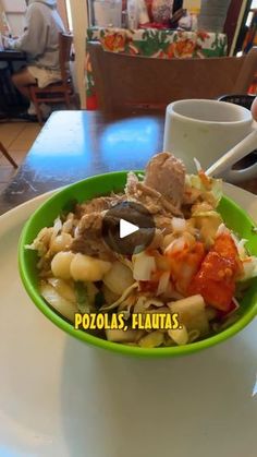 a green bowl filled with food on top of a table