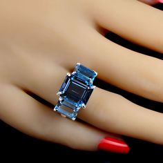 Classic Ring of London Blue Topaz. This elegant three stone ring features three London Blue in emerald cut for a total weight of 14.84 carats. Custom setting of sterling silver. Wear this gorgeous ring morning right through the day and through the evening. No changes by seller. Sizable 8. See your local jeweler for changes. MR2343 Luxury Timeless Topaz Ring With Accent Stones, Luxury Modern Topaz Ring With Diamond Accents, Luxury Topaz Timeless Jewelry, Luxury Diamond Three Stone Topaz Ring, Luxury Blue Topaz Open Ring, Luxury Anniversary Topaz Open Ring, Exquisite Luxury Topaz Ring For Anniversary, Luxury Blue Topaz Jewelry With Gemstone Accents, Luxury Handmade Unique Topaz Ring