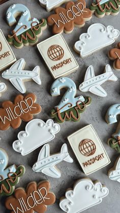 decorated cookies are arranged in the shape of airplanes, clouds, and other things on a tray