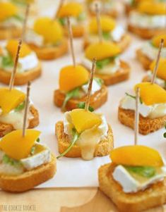 small appetizers with cheese and toppings on them are arranged on a table