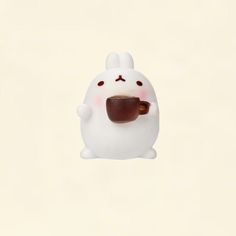 a small white bunny holding a cup of coffee in it's mouth while standing on its hind legs