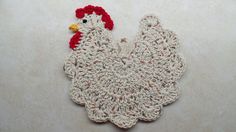 a crocheted chicken is sitting on the floor