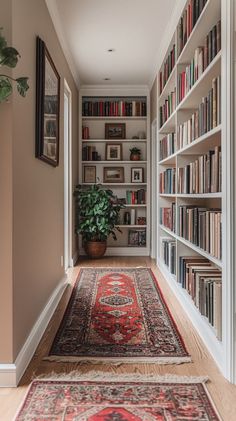 a long narrow hallway with bookshelves and rugs