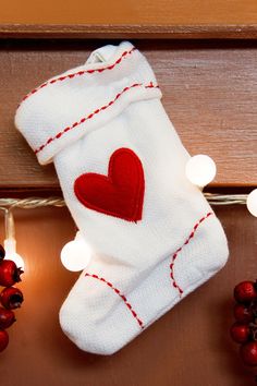 a white sock with a red heart is hanging on a doorknob that says, 100 stocking stuff ideas