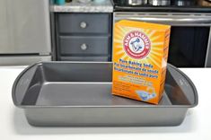 an empty baking pan sitting on top of a counter next to a box of baking powder