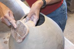 a man is making a vase out of clay