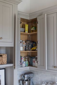 an open cabinet in the corner of a kitchen