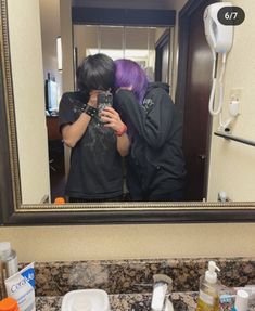 two people are taking a selfie in the mirror