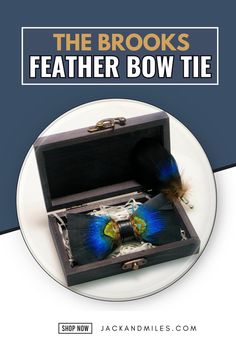 A handcrafted bow tie made from vibrant peacock feathers, featuring iridescent blue and green hues, elegantly placed inside a dark wooden gift box with brass hinges.