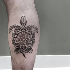 a tattoo on the leg of a man with a turtle