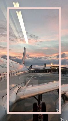 an airplane sitting on the tarmac at dusk with clouds in the sky behind it