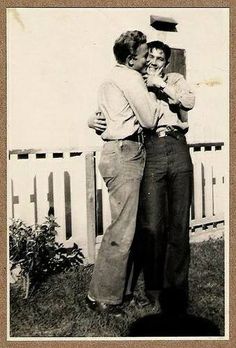 an old black and white photo of two people hugging