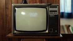 an old tv sitting on top of a wooden table