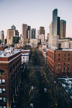 an aerial view of a city with tall buildings and cars parked on the street in front of them