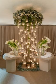 an arrangement of vases with flowers and lights in them