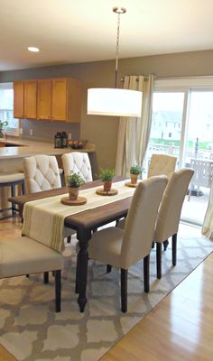 the dining room table is set with beige chairs