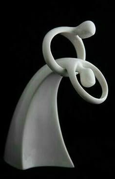 a white sculpture on a black background with the shape of an object in the foreground