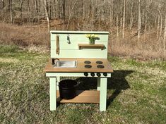 an old fashioned wooden stove and sink in the grass