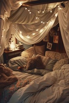 an unmade bed with lights strung from the ceiling